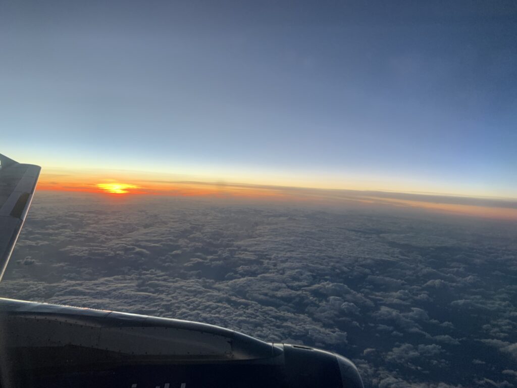 photo from an airplane - flying above the clouds at sunset