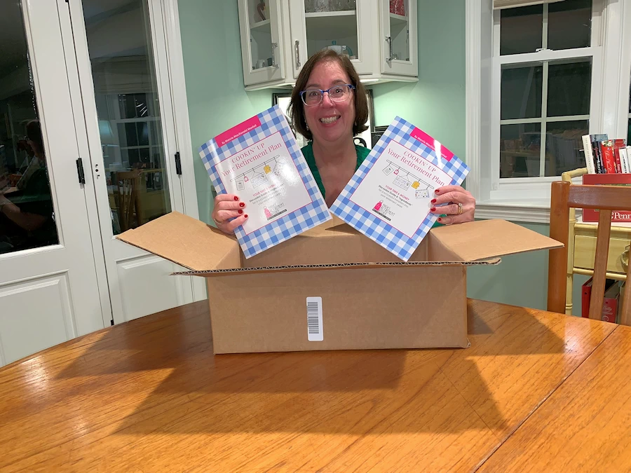 Marcia opening a box of Cookin' Up Your Retirement Plan workbooks